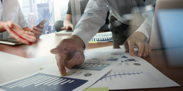 Double exposure of businessman hand working with new modern computer and business strategy as concept
